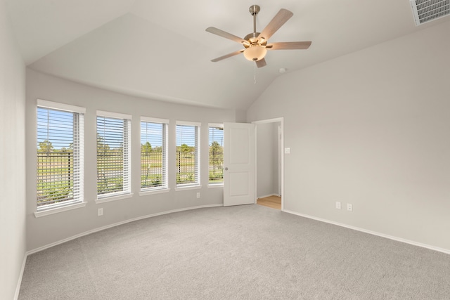 spare room featuring vaulted ceiling, ceiling fan, and light colored carpet