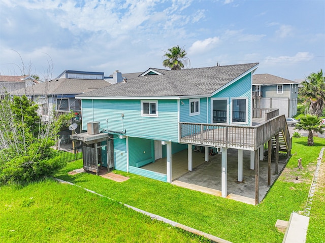 back of property with a patio, a deck, and a lawn