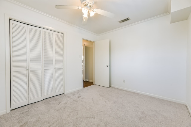 unfurnished bedroom featuring a closet, ceiling fan, ornamental molding, and light colored carpet