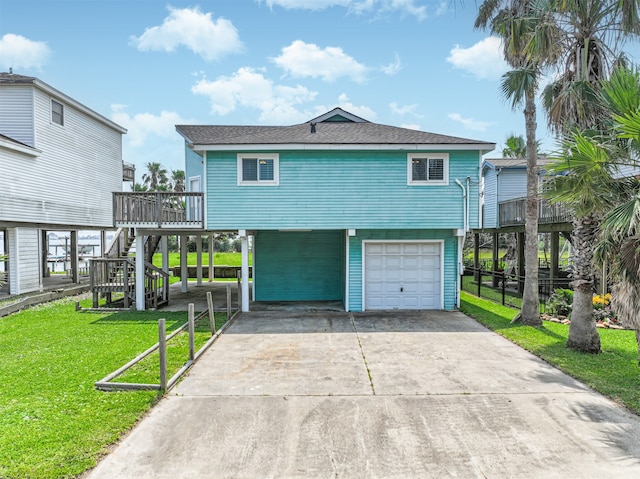 view of front of property featuring a garage, a deck, and a front yard