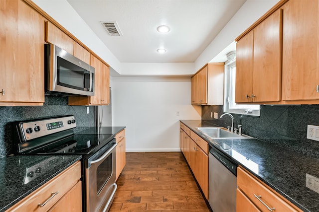 kitchen featuring decorative backsplash, sink, wood-type flooring, and stainless steel appliances