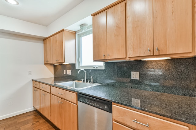 kitchen featuring stainless steel dishwasher, sink, hardwood / wood-style flooring, and tasteful backsplash