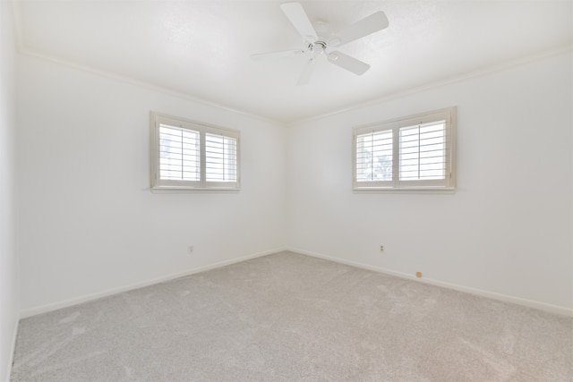 carpeted spare room with crown molding, ceiling fan, and a healthy amount of sunlight