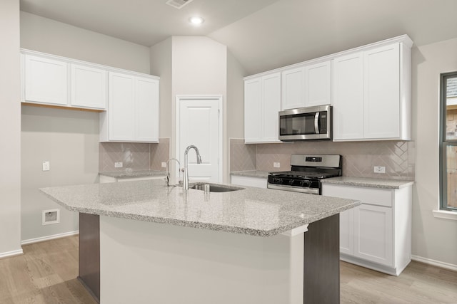 kitchen with white cabinetry, stainless steel appliances, a kitchen island with sink, and sink