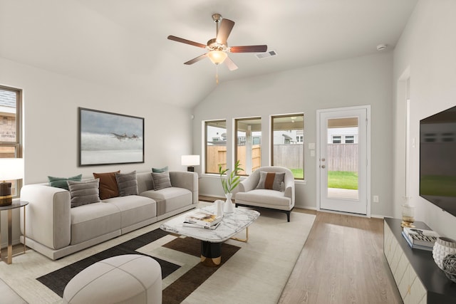 living room featuring a wealth of natural light, ceiling fan, light wood-type flooring, and lofted ceiling