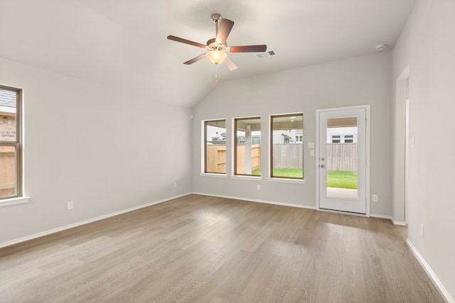 empty room with vaulted ceiling, ceiling fan, and light hardwood / wood-style flooring