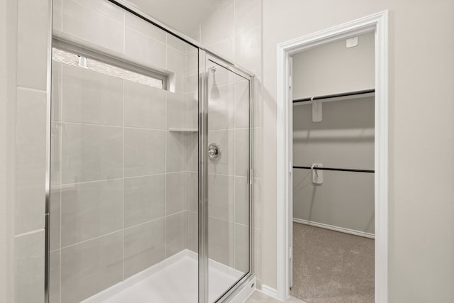 bathroom with a shower with shower door and lofted ceiling