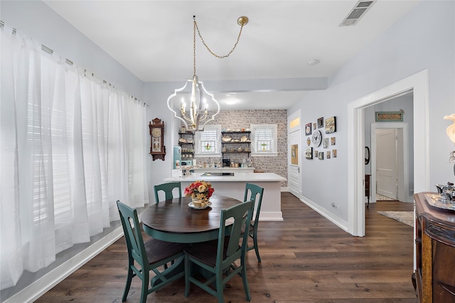 dining room featuring brick wall, an inviting chandelier, and dark hardwood / wood-style flooring