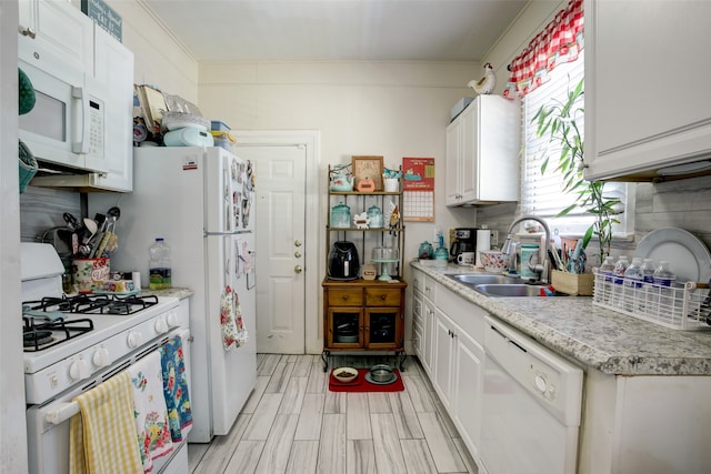 kitchen featuring ornamental molding, white appliances, white cabinets, sink, and tasteful backsplash