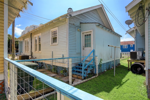 view of side of property with central air condition unit and a yard