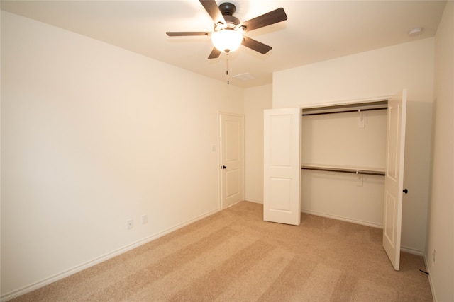 unfurnished bedroom featuring light colored carpet, a closet, and ceiling fan