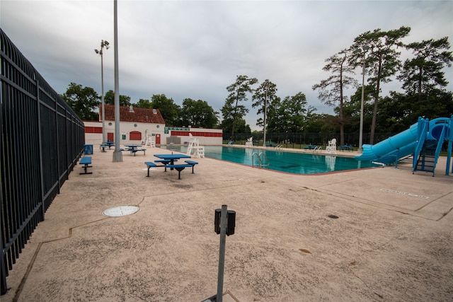 view of pool featuring a water slide and a patio area