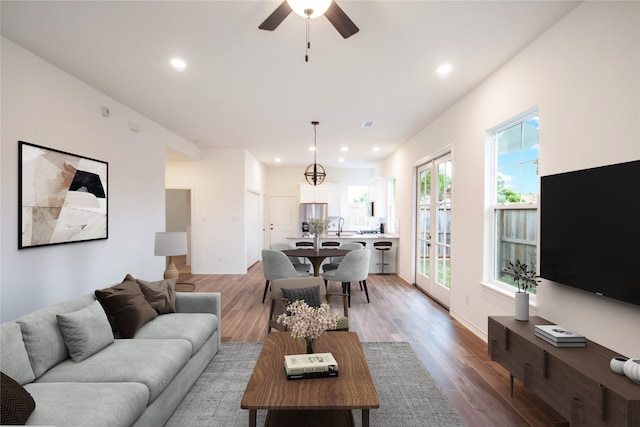 living room with hardwood / wood-style floors, sink, and ceiling fan