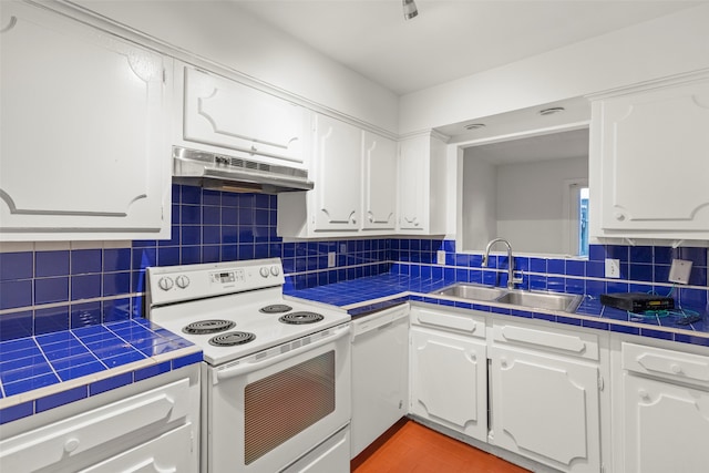 kitchen with white appliances, white cabinetry, and tile countertops