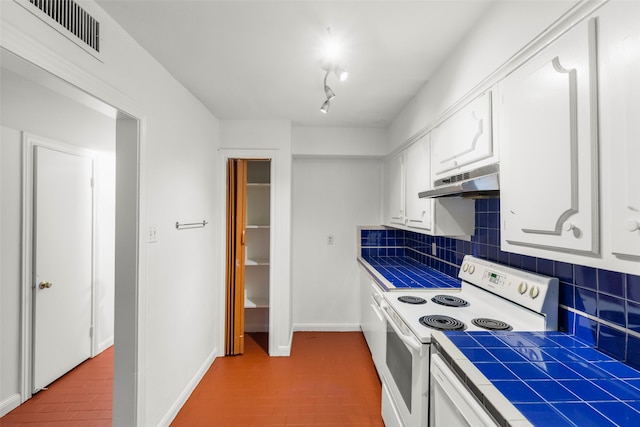 kitchen with white range with electric cooktop, white cabinets, tasteful backsplash, and tile countertops