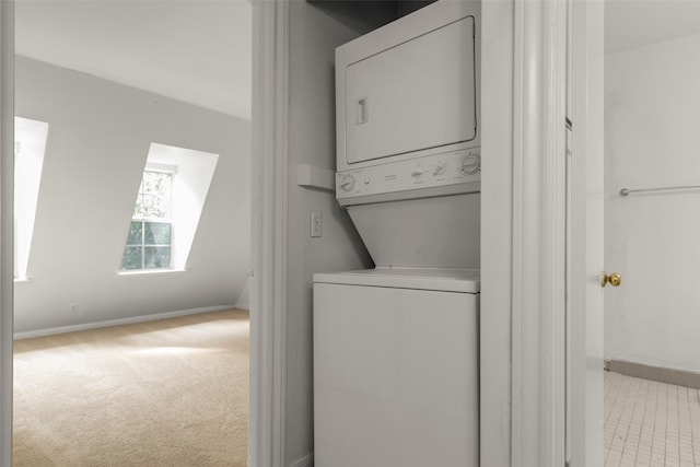 washroom featuring stacked washer / dryer and light colored carpet