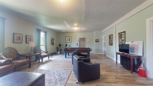 living room with a textured ceiling, light hardwood / wood-style floors, and pool table