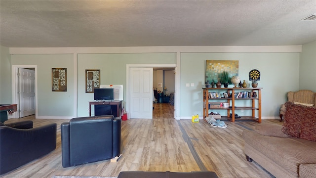 living room with light hardwood / wood-style flooring and a textured ceiling