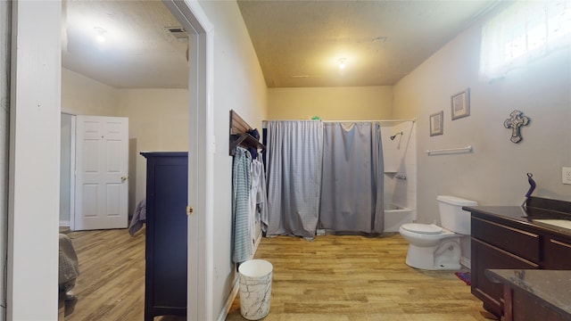 full bathroom featuring vanity, shower / tub combo, hardwood / wood-style flooring, and toilet