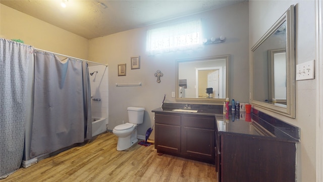 full bathroom with hardwood / wood-style floors, vanity, toilet, and shower / bathtub combination with curtain