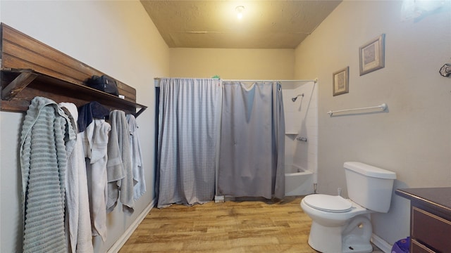 full bathroom featuring vanity, hardwood / wood-style flooring, toilet, and shower / tub combo with curtain