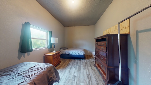 bedroom featuring light hardwood / wood-style flooring and lofted ceiling