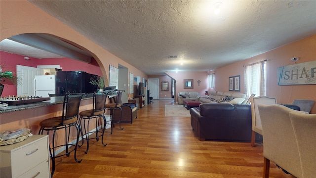 living room with light hardwood / wood-style floors and a textured ceiling