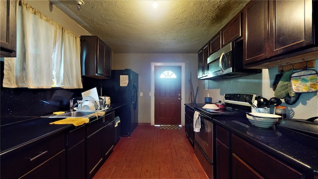 kitchen featuring dark hardwood / wood-style flooring, range with electric cooktop, sink, and dark brown cabinetry