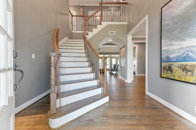 foyer with dark wood-type flooring, a towering ceiling, and a mountain view