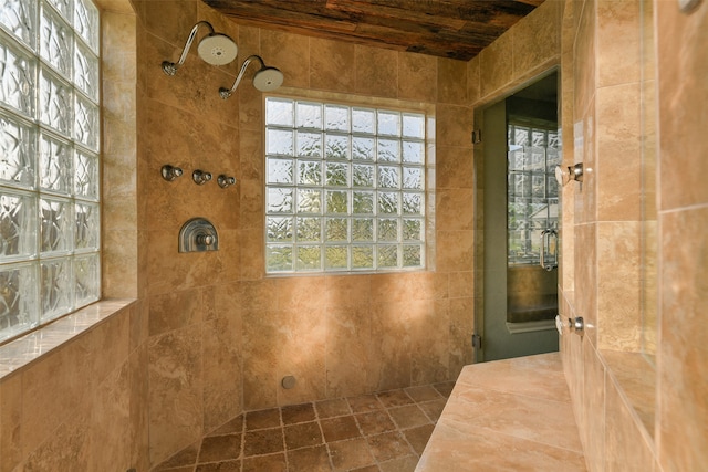 bathroom with a wealth of natural light, wooden ceiling, and tile walls