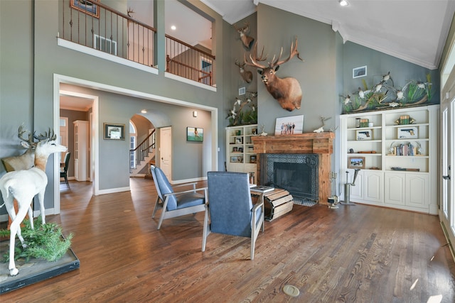 living room with a premium fireplace, high vaulted ceiling, hardwood / wood-style flooring, and crown molding