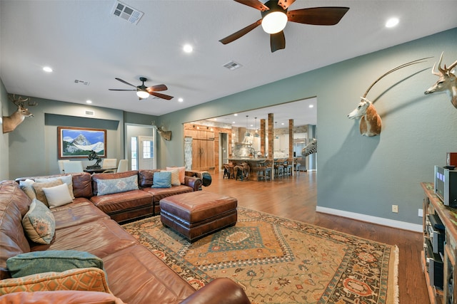 living room with wood-type flooring and ceiling fan