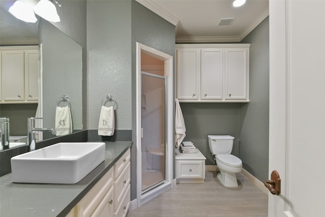 bathroom featuring an enclosed shower, ornamental molding, toilet, and vanity