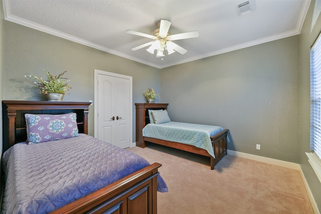 carpeted bedroom featuring a closet, ceiling fan, a textured ceiling, and crown molding