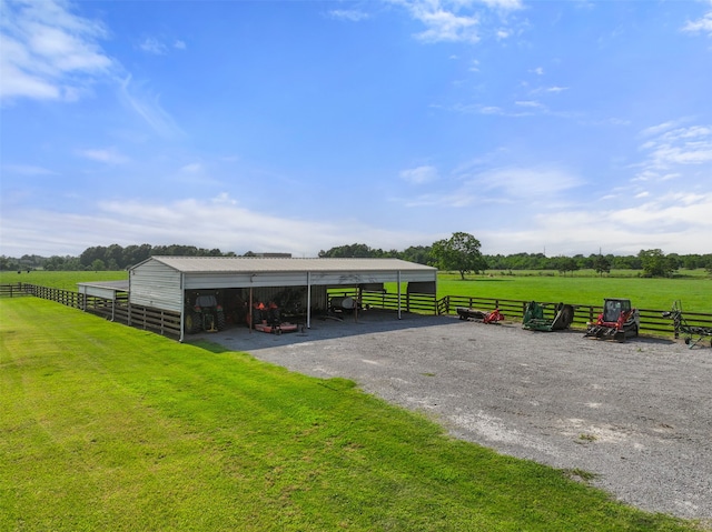 exterior space with an outdoor structure, a rural view, and a lawn