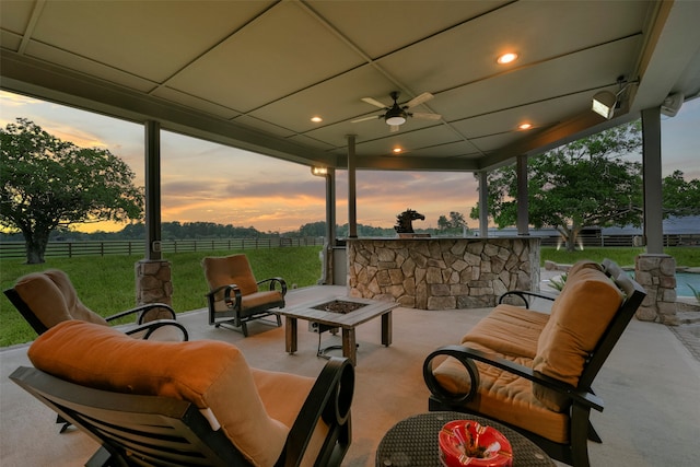 patio terrace at dusk with outdoor lounge area and ceiling fan