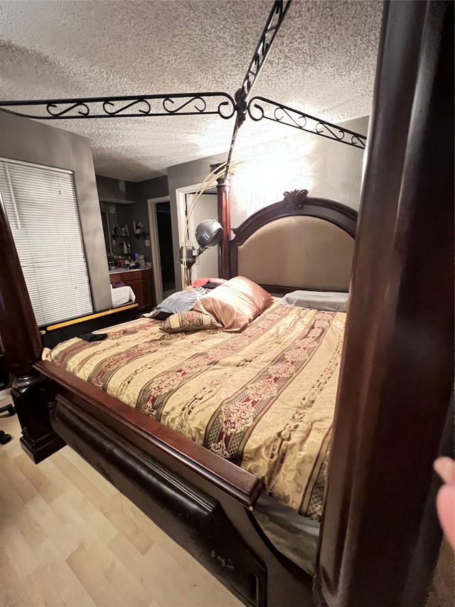 bedroom with wood-type flooring and a textured ceiling