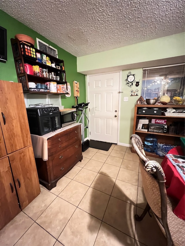 kitchen featuring a textured ceiling and light tile floors