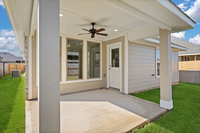 entrance to property with central AC unit, ceiling fan, a patio, and a lawn