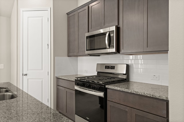 kitchen featuring light stone counters, appliances with stainless steel finishes, backsplash, and dark brown cabinets