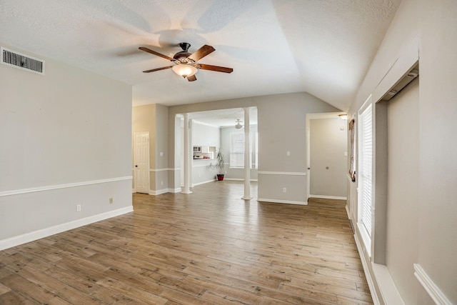 spare room with visible vents, light wood-style flooring, a textured ceiling, and a ceiling fan