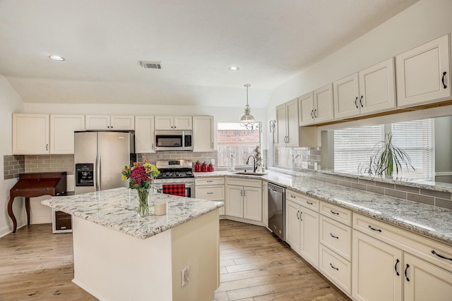 kitchen with decorative backsplash, visible vents, light wood finished floors, and stainless steel appliances