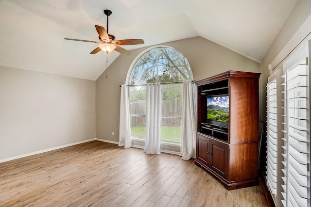 unfurnished living room featuring light wood-style flooring, baseboards, lofted ceiling, and ceiling fan