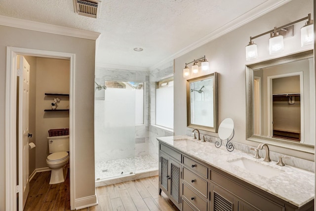 bathroom featuring a sink, visible vents, walk in shower, and wood finished floors