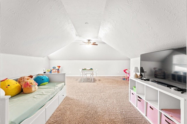 recreation room with carpet, a textured ceiling, ceiling fan, and lofted ceiling