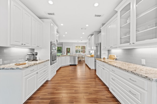 kitchen featuring backsplash, white cabinetry, and stainless steel appliances