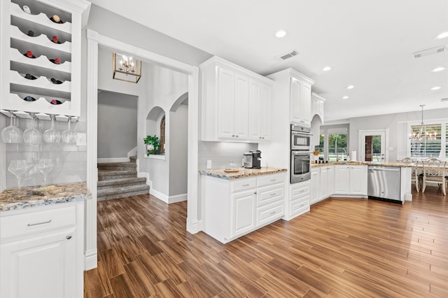 kitchen with white cabinetry, decorative backsplash, dark wood-type flooring, and appliances with stainless steel finishes