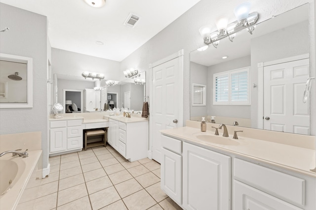 bathroom with tile patterned floors, vanity, and a tub to relax in