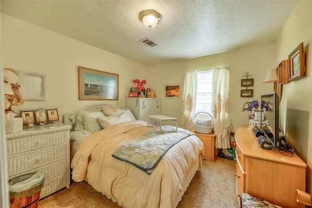 bedroom with light carpet and a textured ceiling