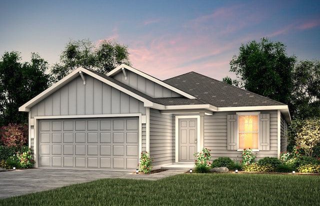 view of front of home with a garage and a lawn